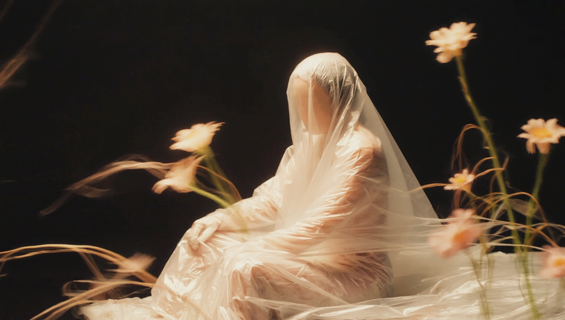 Frames cinematic photography of a person encased completely in thin translucent plastic colorful flowers in natural colors can be seen wrapped underneath the shiny translucent plastic the figure sits in a relaxed pose, complet s-in-motion, .png