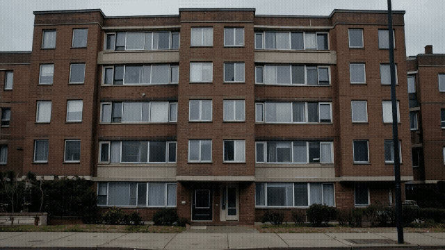 Gen-4_5 static, completely still establishing shot remains completely motionless, focused on a single apartment building the apartment building begins to stretch and curve with an elastic-like qualit.mp4.gif